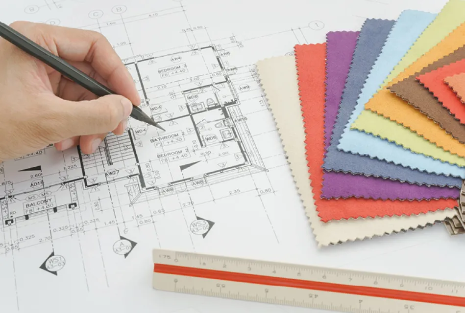 Hand zeichnet Grundriss einer Wohnung auf Bauplan neben bunten Stoffmustern und Lineal. Planung von Möbeln, Sofa und Raumgestaltung für individuelles Wohndesign